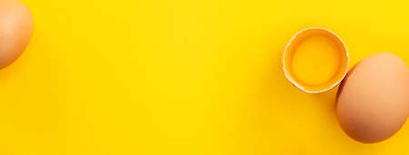 Top view of fresh brown chicken eggs isolated on yellow table background