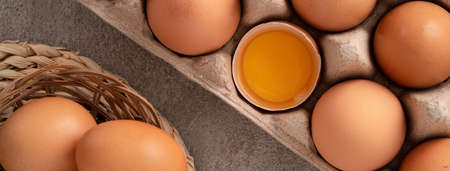 Top view of fresh brown chicken eggs in a plate on gray table background.