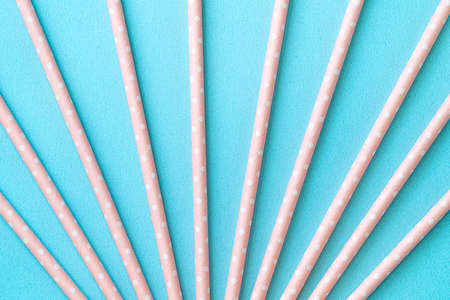Biodegradable spotted pink paper straw set on blue table background, design concept of environmental protection for Earth Day.の写真素材
