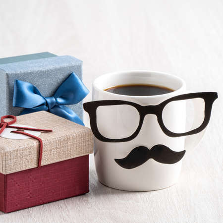 Father's day design concept. Close up of cup of coffee and gift box for daddy funny idea.の写真素材