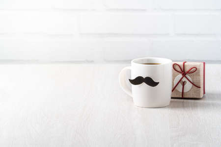 Father's day design concept. Close up of cup of coffee and gift box for daddy funny idea.の写真素材