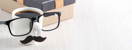 Father's day design concept. Close up of cup of coffee and gift box for daddy funny idea.の写真素材