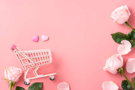 Mother's Day shopping design concept background with pink rose flower and cart on pink table backgroundの写真素材