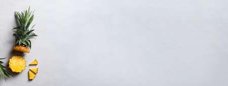 Top view of fresh cut pineapple with tropical leaves on dark blue background.の写真素材