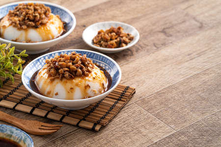 Taiwanese savory rice pudding Wa gui, rice cake with chopped dried radish topping and soy sauce in a...
