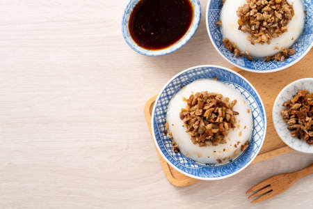 Taiwanese savory rice pudding Wa gui, rice cake with chopped dried radish topping and soy sauce in a bowl.の写真素材