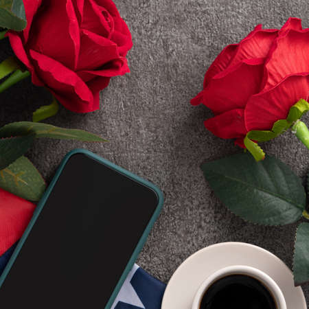 Concept of US Independence day or Memorial day with smart phone and a cupt of coffee. National flag over dark gray table background.の写真素材