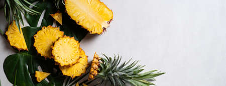 Top view of fresh cut pineapple with tropical leaves on dark blue background.の写真素材