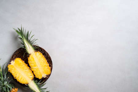 Top view of fresh cut pineapple with tropical leaves on dark blue background.の写真素材