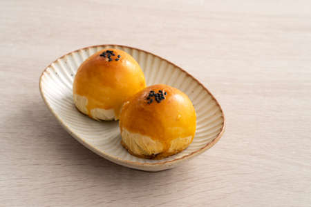 Design concept of Moon cake yolk pastry, mooncake for Mid-Autumn Festival holiday on wooden table backgroundの写真素材