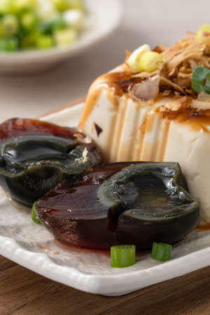 Delicious Chilled tofu and century egg food with soy sauce and bonito flakes topping in Taiwan.の写真素材