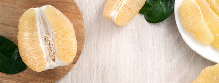 Top view of fresh peeled pomelo on bright wooden table background for Mid-Autumn Festival fruit.の写真素材