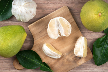 Top view of fresh peeled pomelo on bright wooden table background for Mid-Autumn Festival fruit.の写真素材