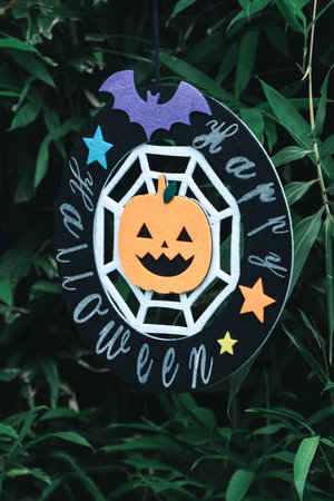 Cute Halloween decorations hanging on a tree in the forest to celebrate Halloween, festive holiday...