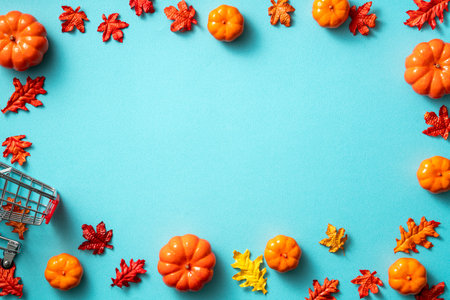 Creative Halloween autumn shopping design concept decoration on blue paper table background with pumpkin, autumn leaves and copy spaceの写真素材