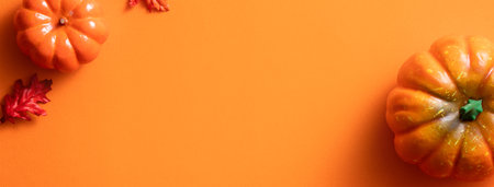 Creative Halloween design concept decoration on orange paper table background with pumpkin, autumn leaves and copy spaceの写真素材
