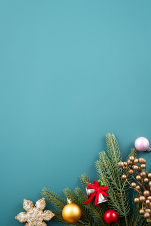Christmas background design concept, holiday decoration ornament composition with Christmas tree branch, golden bell with copy space isolated on green table.の写真素材