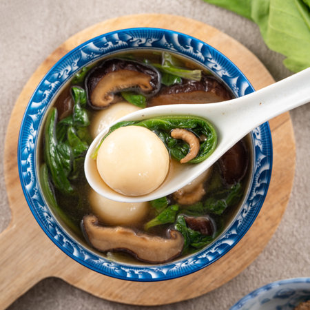 Eating big tangyuan yuanxiao (tang yuan, glutinous rice dumpling balls) with savory soup in a bowl...
