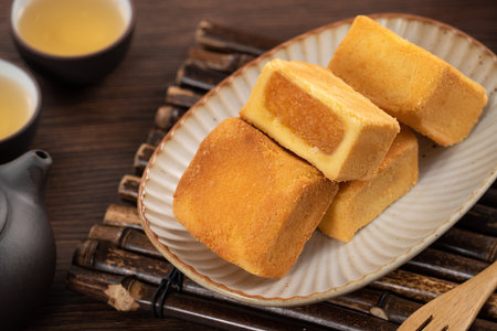 Delicious Taiwanese pineapple cake pastry dessert in a plate on wooden table background with hot tea.の写真素材