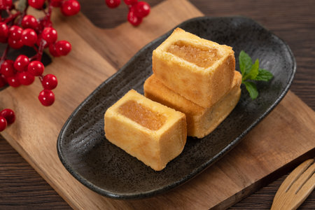 Delicious Taiwanese pineapple cake pastry dessert in a plate on wooden table background with hot tea.の写真素材