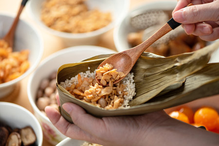 Making zongzi food - preparing and wrapping Chinese rice dumpling at home for Duanwu Dragon Boat Festival celebration, lifestyle.の写真素材