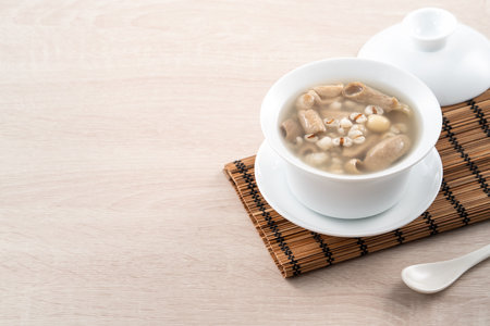 Four Tonics Soup. Delicious homemade Taiwanese traditional Chinese herb flavor food with herbs, pork intestine on wooden table backgroundの写真素材