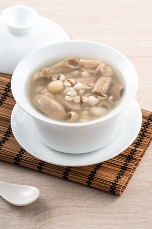 Four Tonics Soup. Delicious homemade Taiwanese traditional Chinese herb flavor food with herbs, pork intestine on wooden table backgroundの写真素材