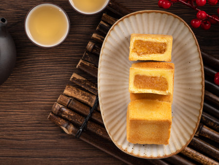 Delicious Taiwanese famous pineapple cake pastry dessert in a plate on wooden table background with hot tea.の写真素材