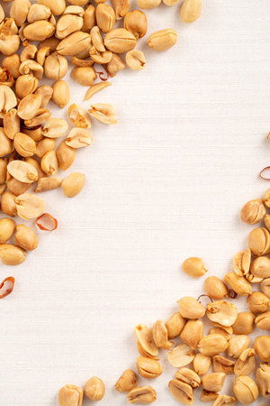 Spicy flavored peanut kernel spilling on white table background.の写真素材