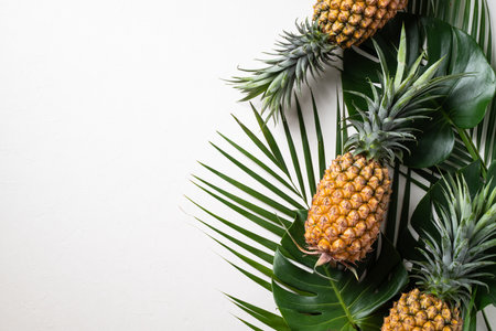 Top view of fresh pineapple with tropical monstera leaves on white background.の写真素材