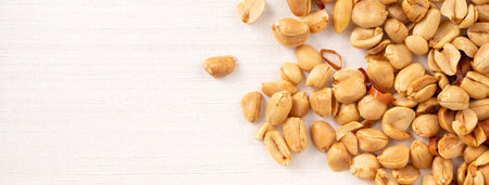 Spicy flavored peanut kernel spilling on white table background.の写真素材