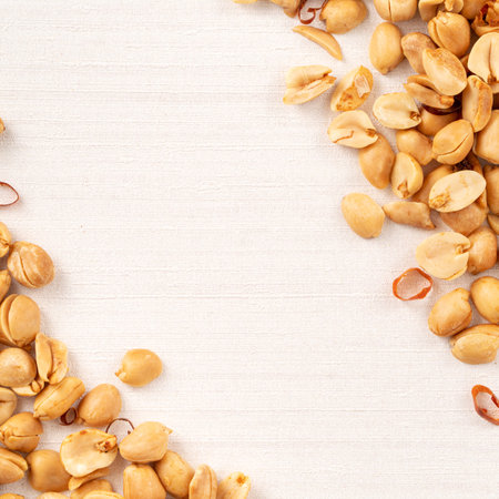 Spicy flavored peanut kernel spilling on white table background.の写真素材