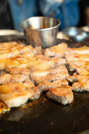 Pan-fried black pork meal in Jeju Korean restaurant, fresh delicious korean food cuisine on iron plate with lettuce, kimchi, banchan and sauce, lifestyle.の写真素材