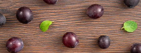 Delicious bunch of purple grapes fruit spilled over wooden table background.の写真素材