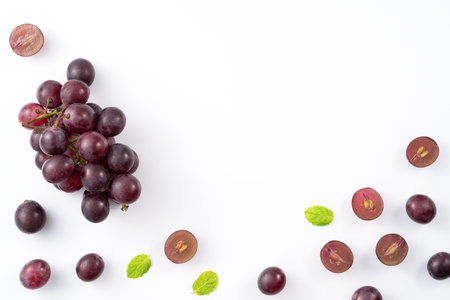 Delicious bunch of purple grapes fruit spilled over white table background.の写真素材
