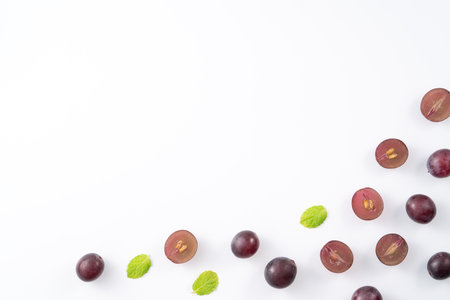 Delicious bunch of purple grapes fruit spilled over white table background.の写真素材