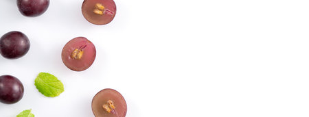Delicious bunch of purple grapes fruit spilled over white table background.の写真素材