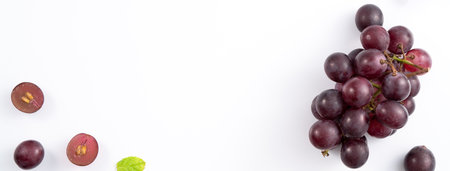 Delicious bunch of purple grapes fruit spilled over white table background.の写真素材