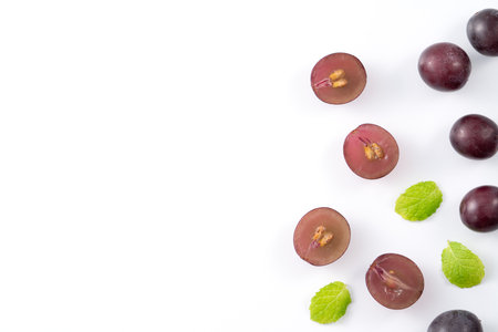 Delicious bunch of purple grapes fruit spilled over white table background.の写真素材