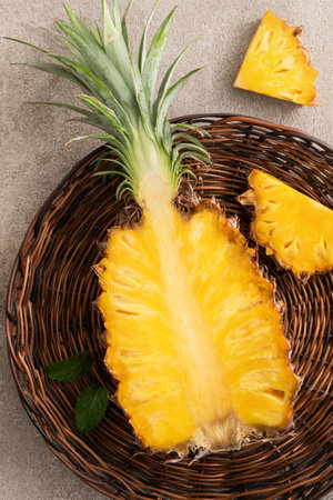 Top view of fresh cut pineapple with tropical leaves on gray table background.の写真素材