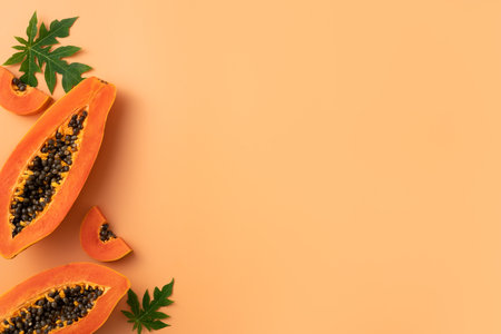 Cut Papaya over orange table background for tropical fruit design concept, top view copy space.の写真素材