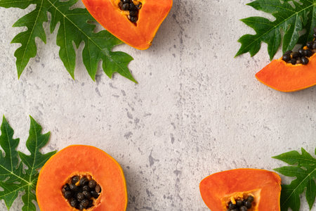 Cut Papaya over gray table background for tropical fruit design concept, top view copy space.の写真素材