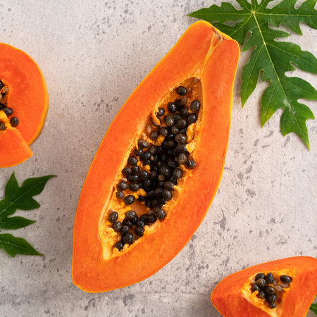 Cut Papaya over gray table background for tropical fruit design concept, top view copy space.の写真素材