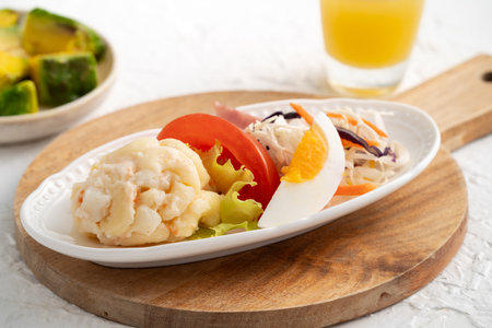 Fresh avocado lettuce salad bowl with sliced chicken meat and rotini on a plate on white table background.の写真素材