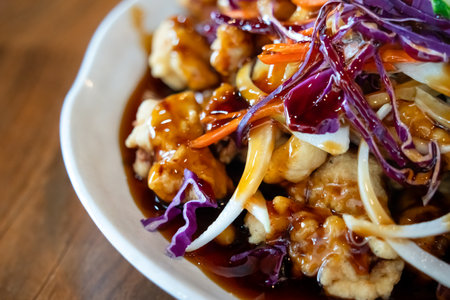 Delicious Korean-style Chinese sweet and sour sauced deep fried pork, Tangsuyuk, with shredded cabbage, cucumber, onion and carrots.の写真素材