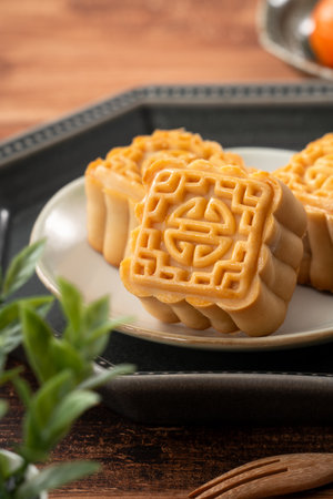 Delicious Cantonese moon cake for Mid-Autumn Festival food mooncake on wooden table background for afternoon tea, holiday celebration serving.の写真素材
