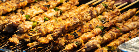 Grilling barbecue meat skewer kebab at traditional night market stall, delicious street food in South Korea.の写真素材
