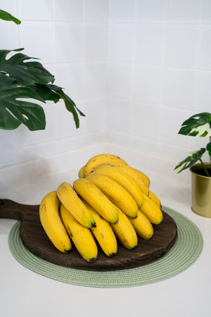 A bunch of fresh banana lie on the table in a modern kitchen, healthy life concept.の写真素材