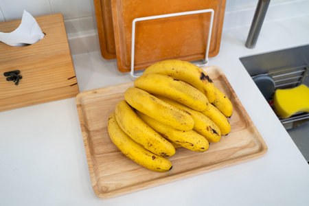 A bunch of fresh banana lie on the table in a modern kitchen, healthy life concept.の写真素材