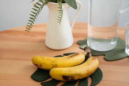 A bunch of fresh banana lie on the dining table in a modern kitchen, healthy life concept.の写真素材